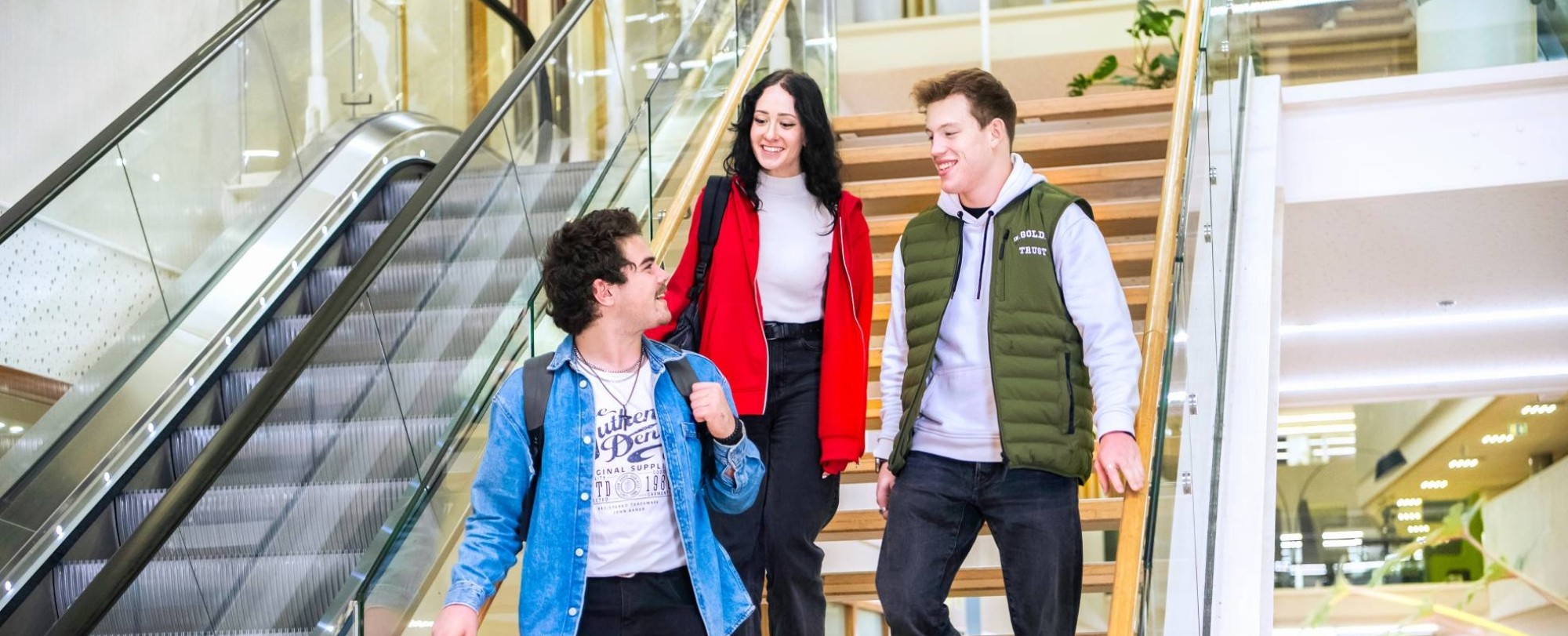 Drie studenten Leraar Natuurkunde lopen samen van de trap af.