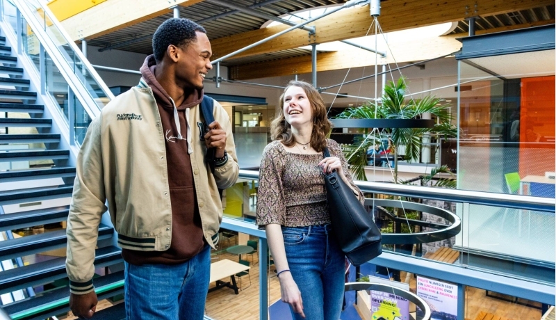 studenten van learning and development lopen door de gang in de HAN campus
