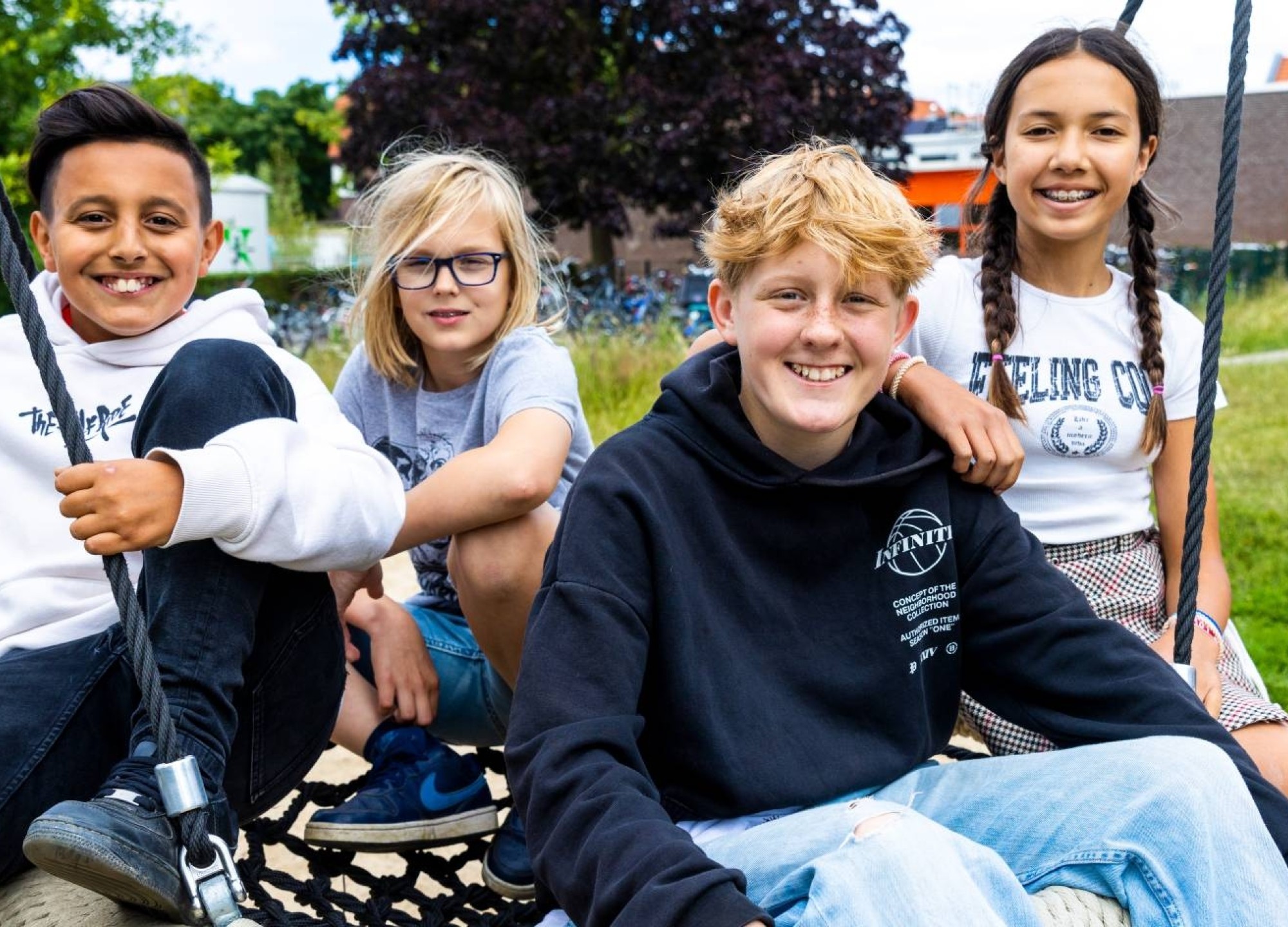 Vier leerlingen zitten buiten op een schommel. Foto van de opleiding leraar basisonderwijs 