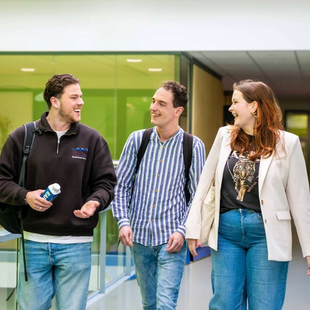 Studenten op de HAN wandelen samen en spreken elkaar