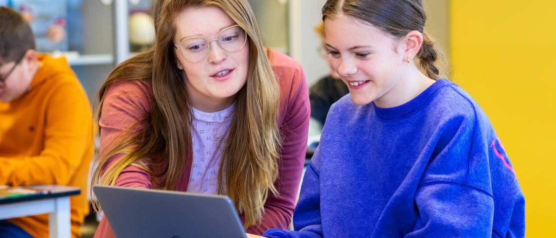 Fotoshoot op het Citadel 2024. De docente kijkt mee op het laptopscherm van een meisje in de klas. 