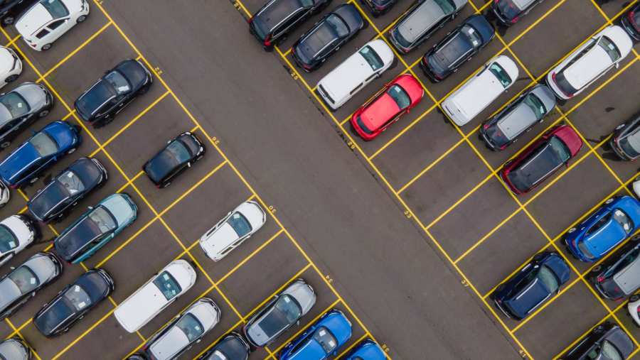 Bovenaanzicht van grote partij auto's die op een parkeerplaats klaarstaan om ete verschepen.