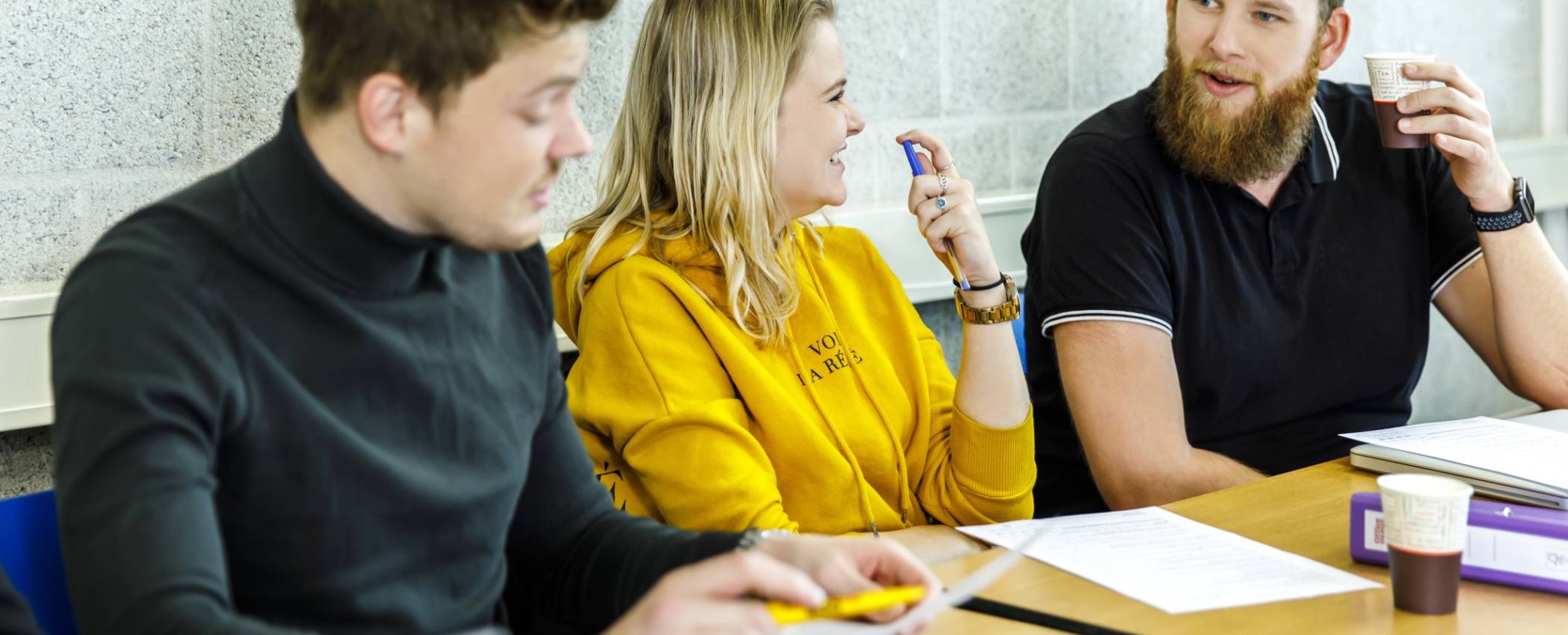 drie mensen op een rij aan het overleggen