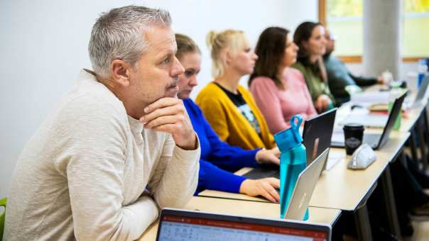 masterstudenten op een rij, met een close-up op de voorste die gefocust oplet