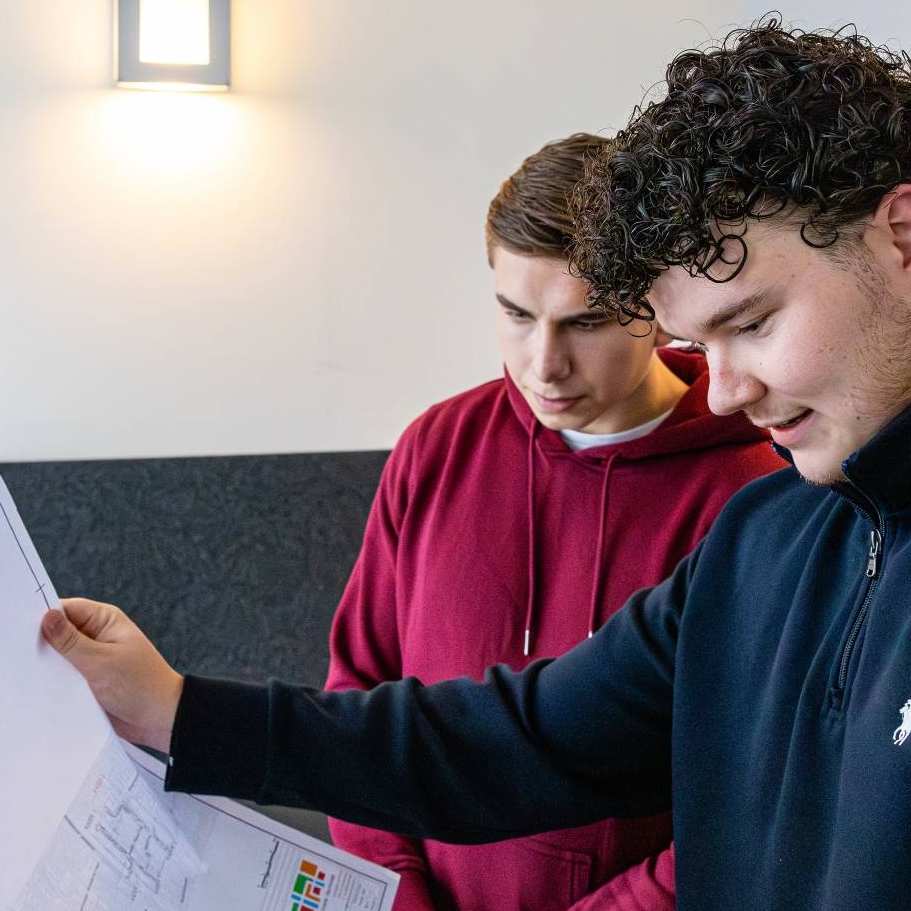 Twee mannen checken samen een grote bouwtekening