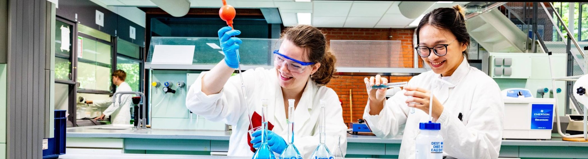 studenten pipetteren in het chemielab