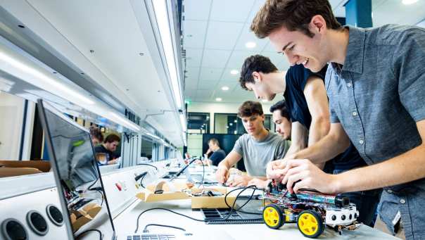 Student Marlo van embedded systems engineering werkt aan een programmeerbare auto in het lab.