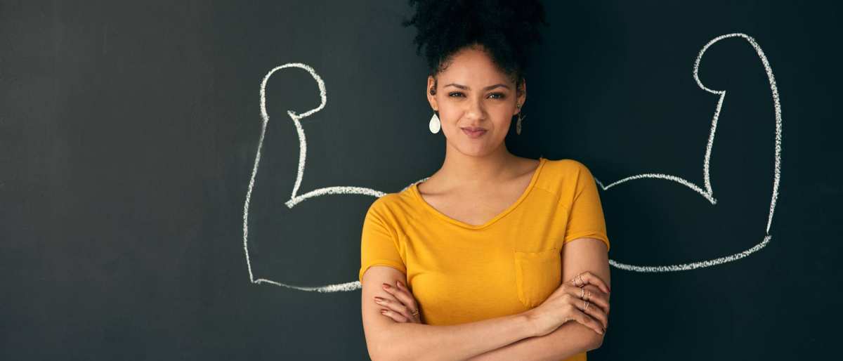 Vrouw voor schoolbord met sterke armen getekend