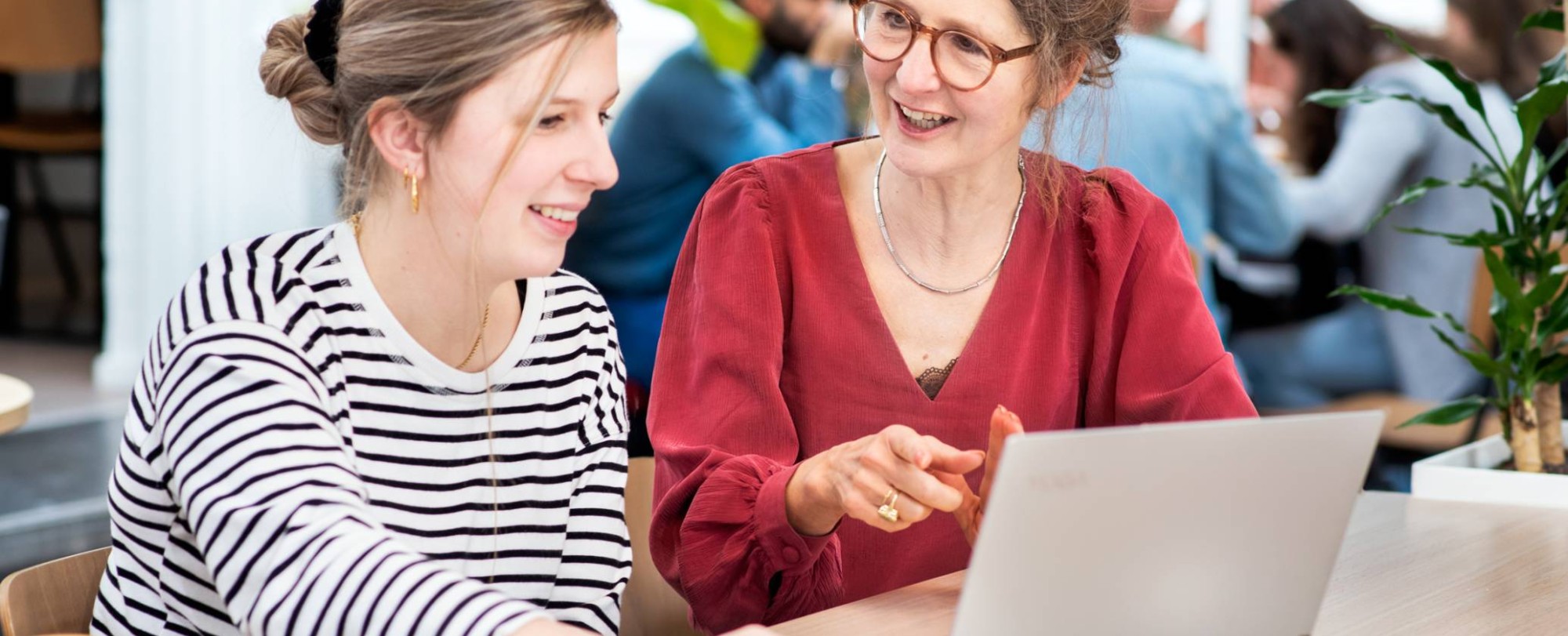 Docent in overleg met student met laptop