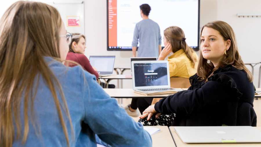 Alpo studenten kijken naar elkaar, terwijl de leraar naar een grote scherm kijkt