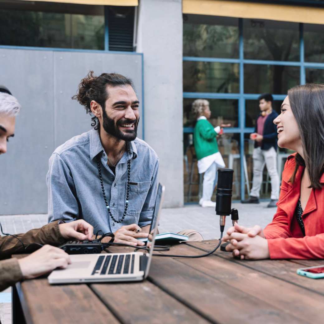 Deelnemers aan een cursus digitale marketing oefenen met het opnemen van een podcast.