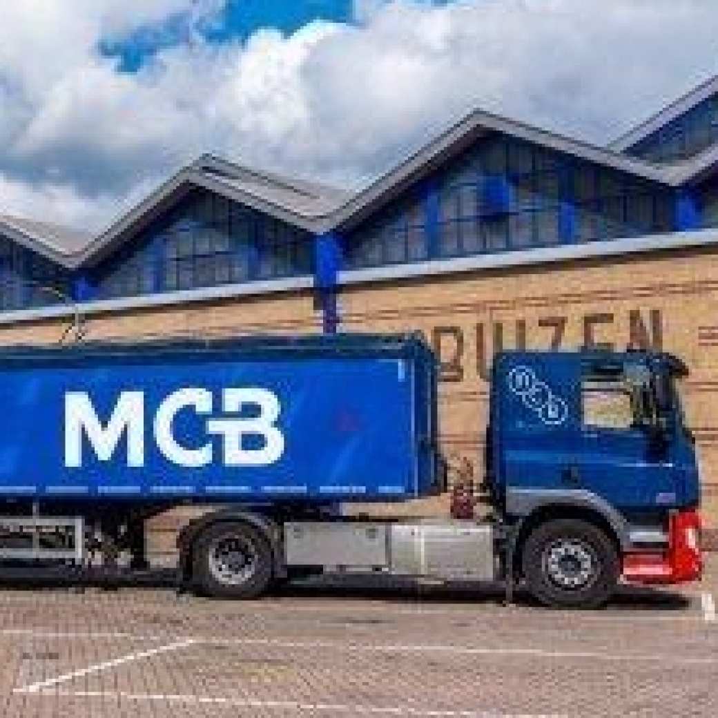 Blauwe vrachtwagen met MCB logo