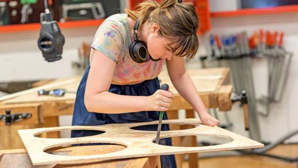 Meisje bewerkt hout in houtlokaal