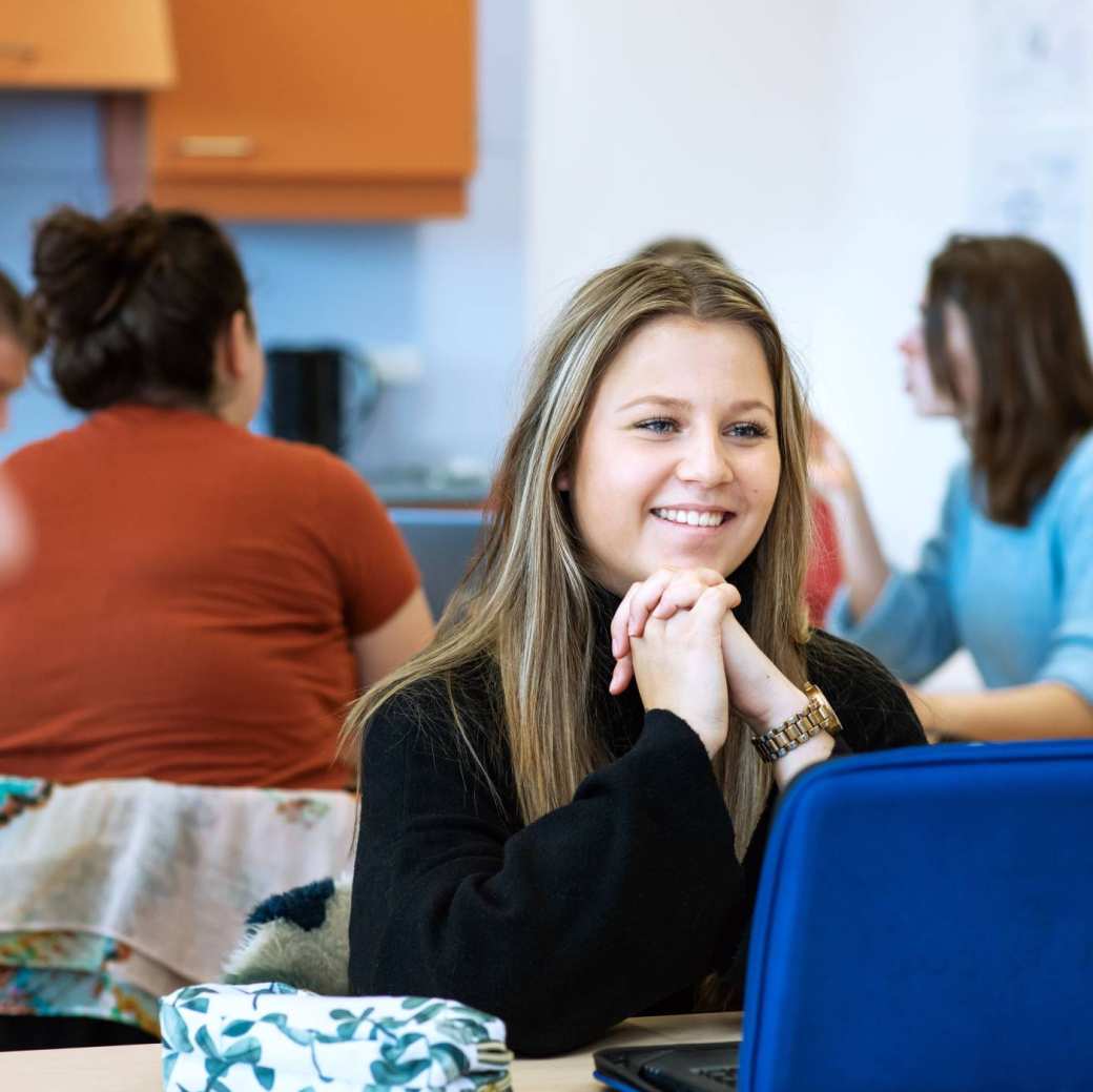 student ergotherapie zit achter laptop en is in gesprek