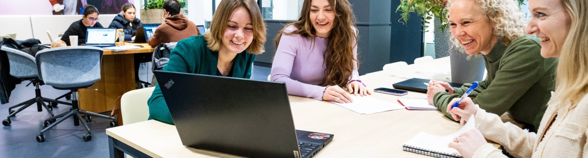 Twee deelnemers van de post-hbo Plannen in de Zorg praten met elkaar en lachen