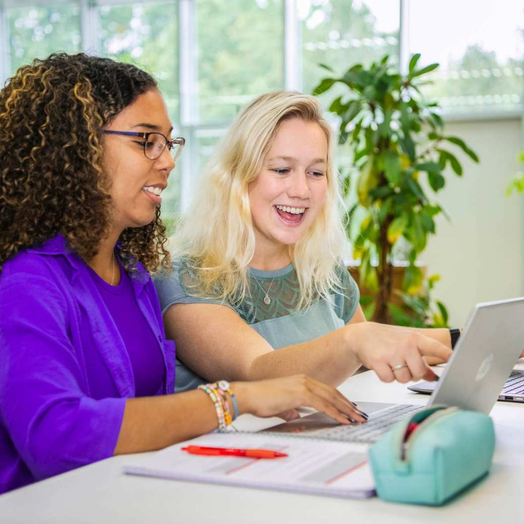 Twee studenten kijken op laptop