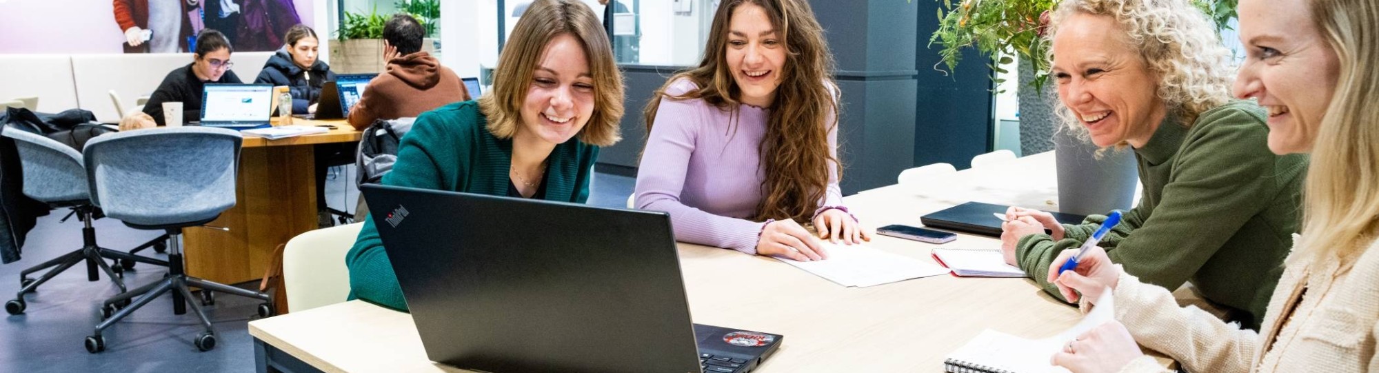 Post-hbo Bedrijfskunde, deelnemers werken samen aan een opdracht met laptop. 