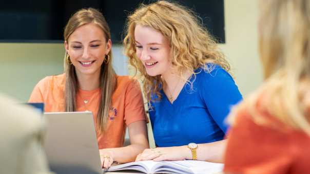 2 studenten zijn tijdens les Verpleegkunde aan het werk op de laptop