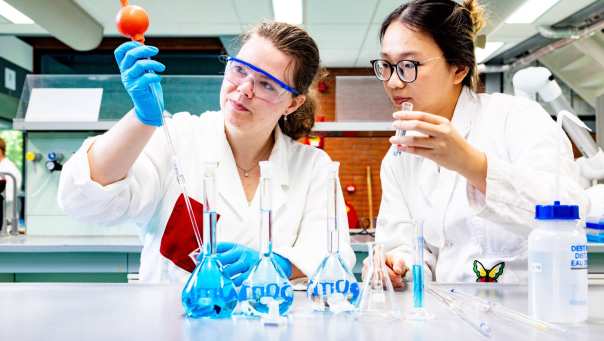 studenten pipetteren in het chemielab