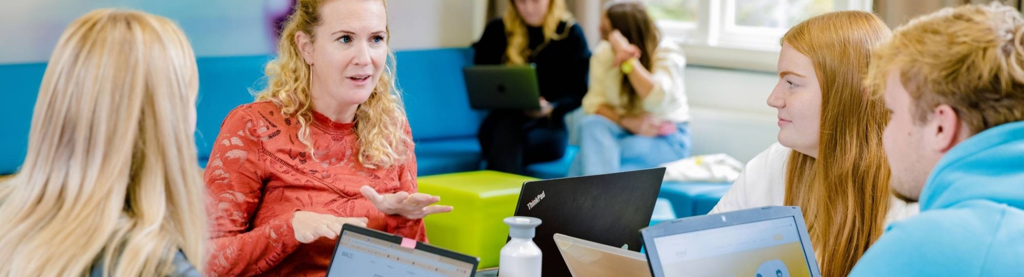 Communicatie studenten en docent aan tafel