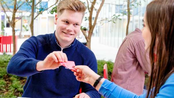 Student geeft briefje aan andere student. Master Circulaire Economie 2024.