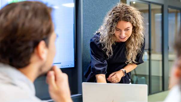 Duaal student Commerciële Economie aan het werk op laptop met medestudenten.