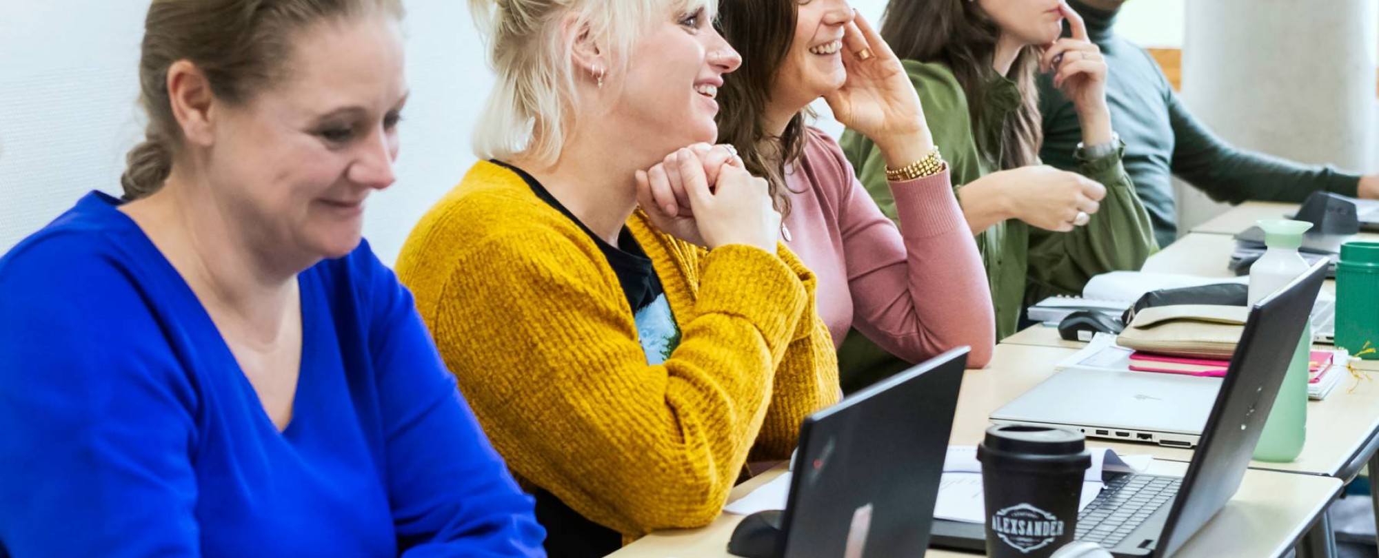 Foto van Master Ontwerpen van Eigentijds Leren. 5 masterstudenten op een rij luisteren of zijn aan het werk. 