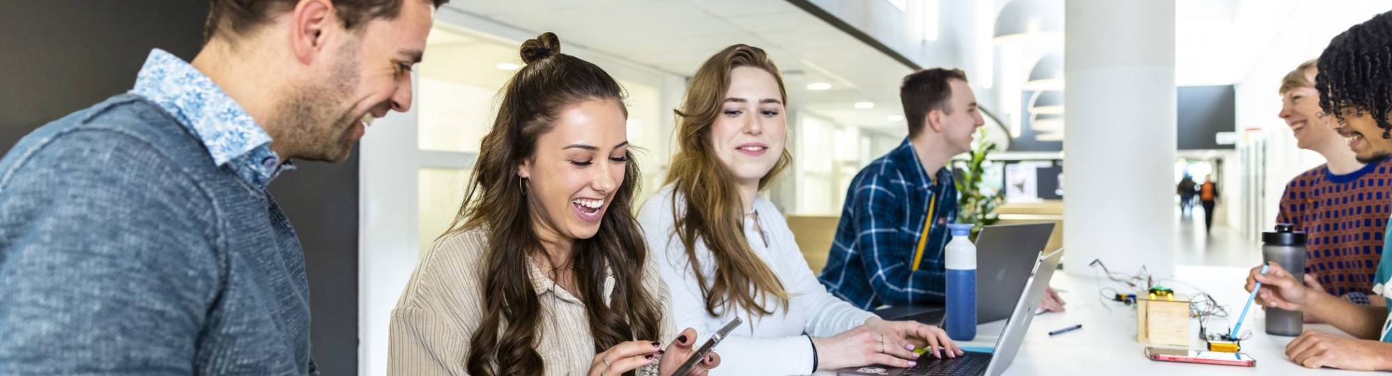 Studenten CMD werken aan een studieopdracht in de medialounge