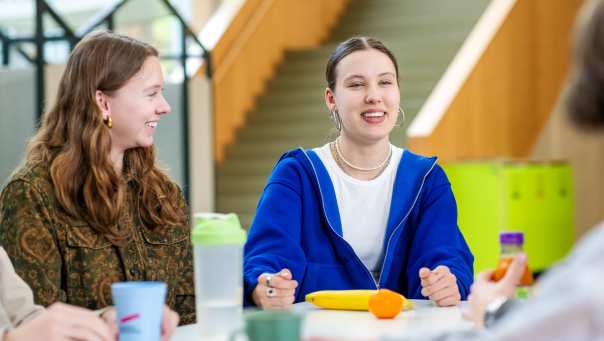 Twee studenten lachen in de pauze. 