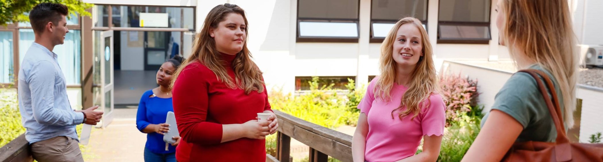 HBO master studenten ontmoeten elkaar op de campus buiten op de brug