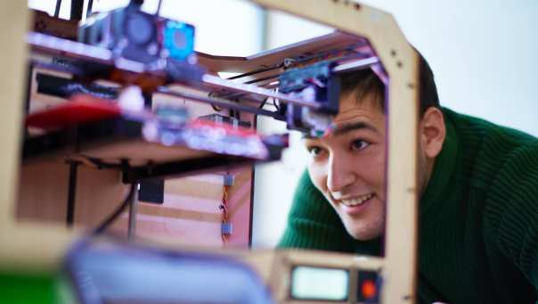 Man kijkt naar een 3d printer