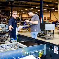 Technische Bedrijfskunde studenten werken samen op werkvloer.