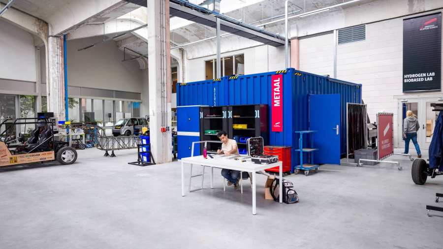 Overzicht van de container op het Mobility Innovation lab bij HAN Connectr op het IPKW. Een student werkt met metaal.