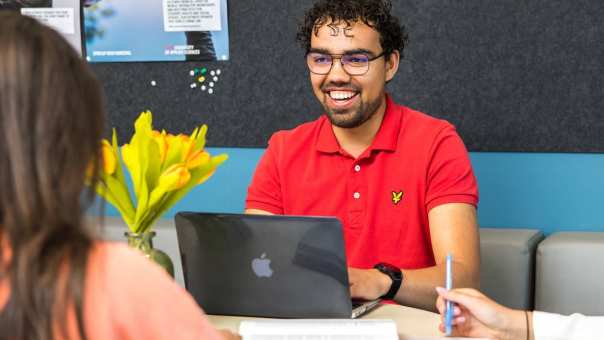 2 mannelijke studenten Social Work lachen tijdens een college op de HAN want zij zijn 21+ en gestart met de studie Social Work.