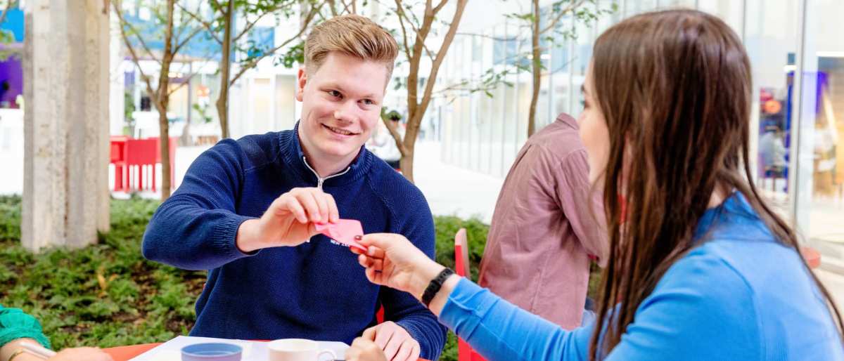 Student geeft briefje aan andere student. Master Circulaire Economie 2024.