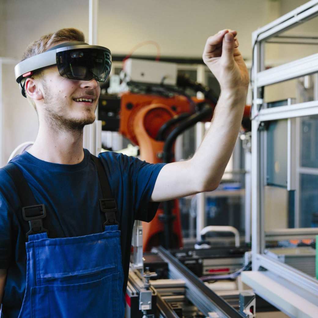 Man / student werkt met AR bril op. Virtual reality in een productieomgeving. 