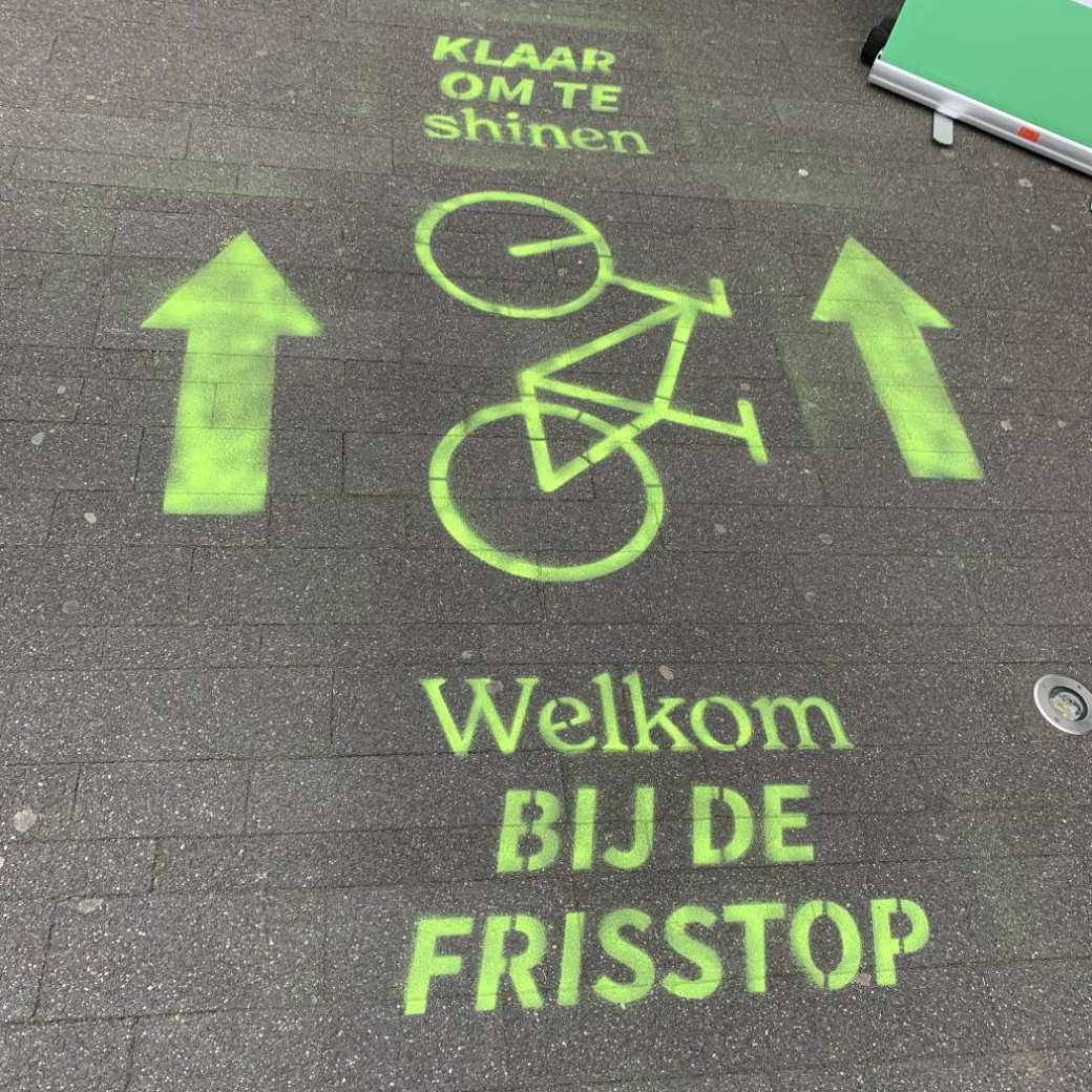 Afbeelding van een afdruk op de grond met daarop de tekst Frisstop in het groen.