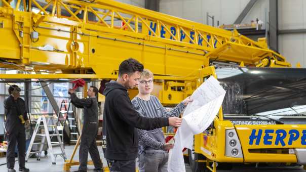 Twee studenten van de associate degree Constructeur Werktuigbouwkunde op hun werkplek. Rechtenvrije foto uit de techniekbeeldbank. Academie Engineering en Automotive. 