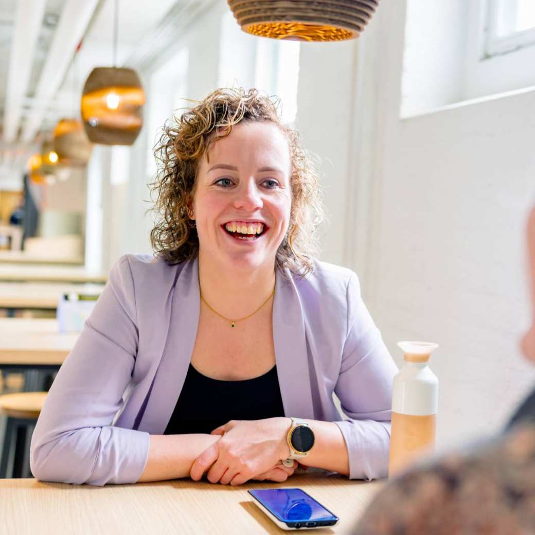 Vrouw in gesprek, moet lachen. Tijdens de cursus acute pijn service, in de kantine.