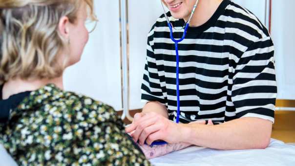 Student is bloeddruk aan het meten bij andere student tijdens les Verpleegkunde deeltijd