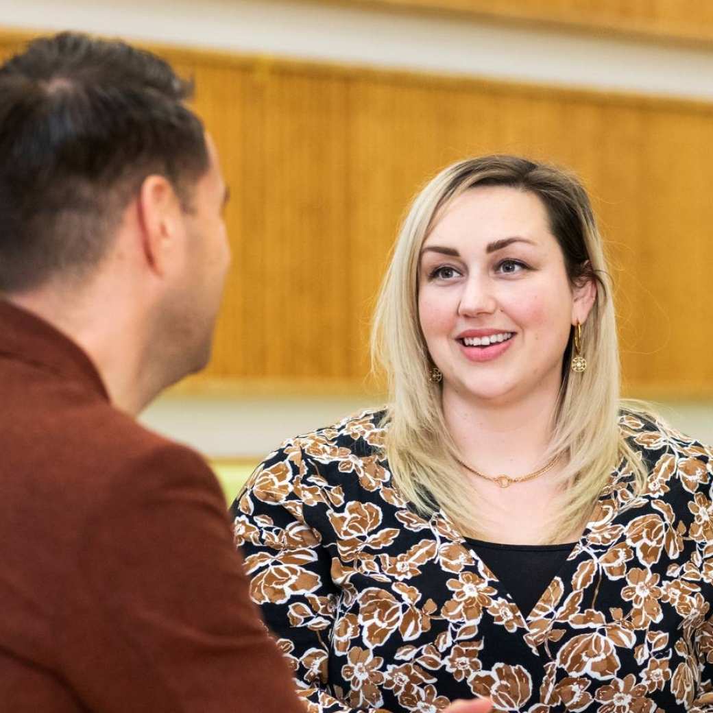 Twee vrouwen lachen tijdens een gesprek. 