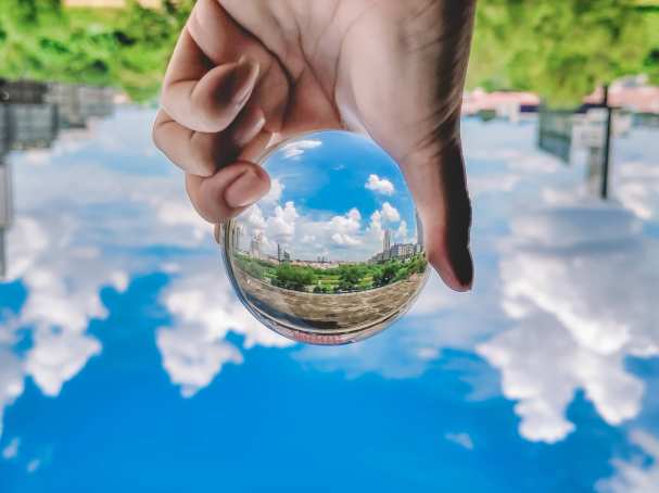 Foto van een glazen bol met natuur en stad