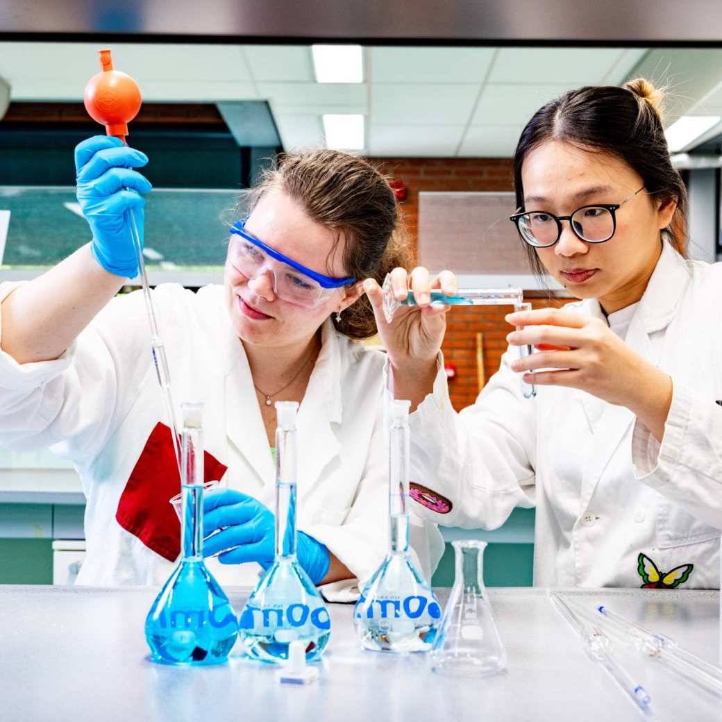 studenten pipetteren in het chemielab