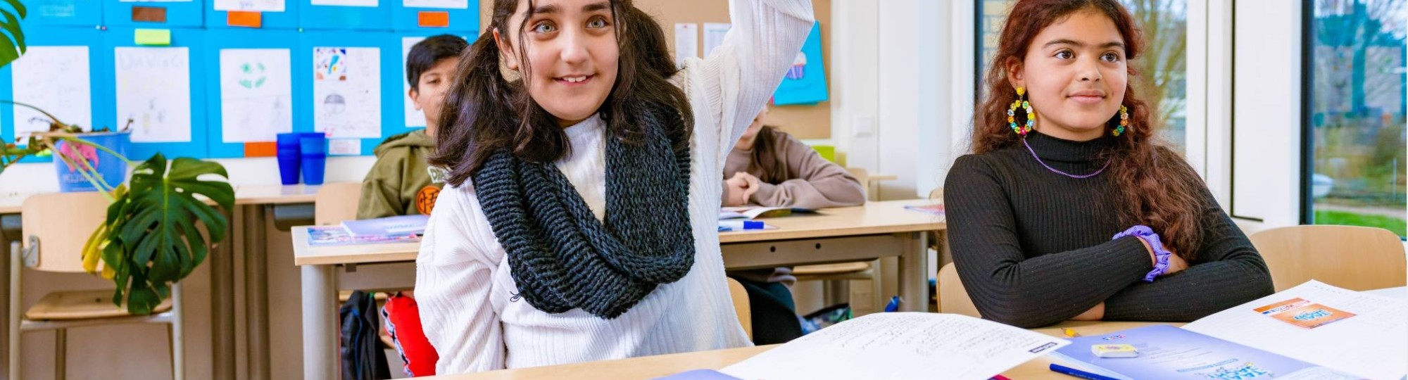 Groep 5,6,7 op de school Da Vince. De leerling steekt haar vinger op in de klas. 