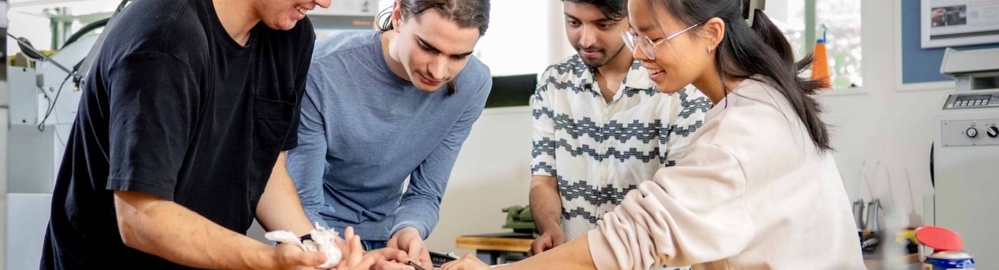 Studenten werktuigbouwkunde moeten samenwerken bij het op spanning brengen van een veer.