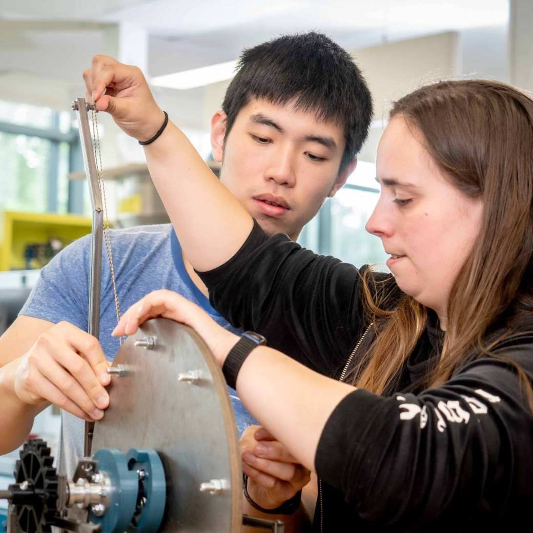 Twee studenten werktuigbouwkunde werken samen aan een kartrol.