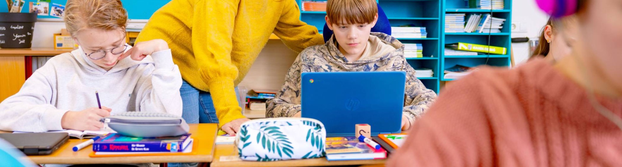 Speciaal Onderwijs op de school Lichtenbeek. De lerares kijkt mee op de laptop van de leerling. 
