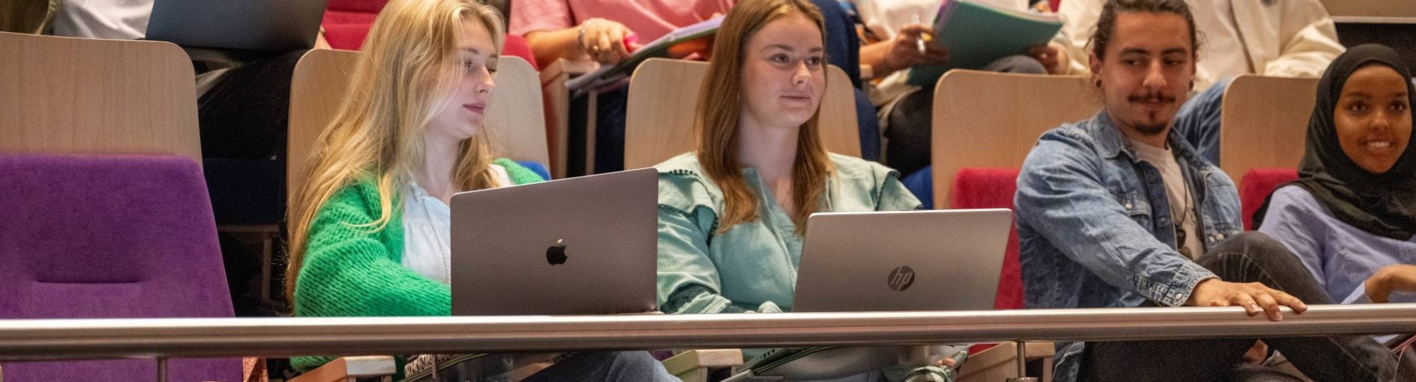 Studenten hebben hoorcollege en luisteren naar docent.