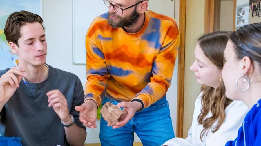 De leraar vertelt aan de studenten over een steen. 