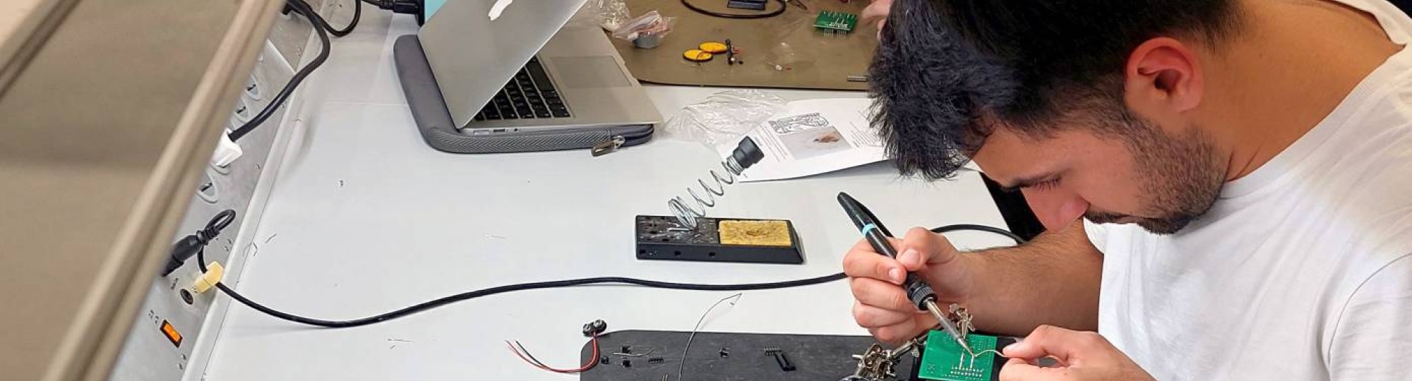 Embedded Hardware Engineering cursisten van YER solderen op printplaatje een deel van een tekenrobot